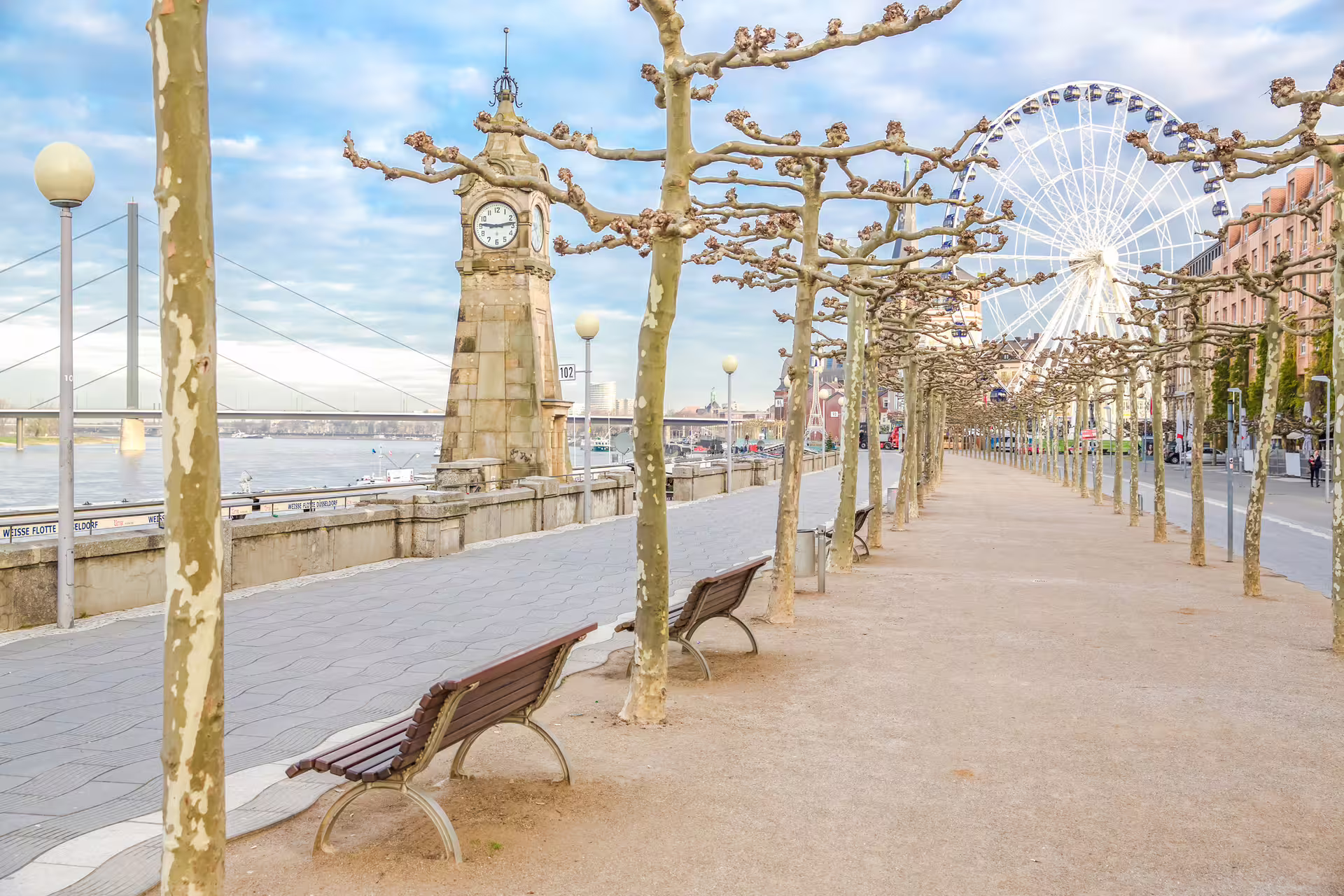 Düsseldorf Rhine promenade with clock tower and Ferris wheel, highlight stop on a 1-day audio walking tour
