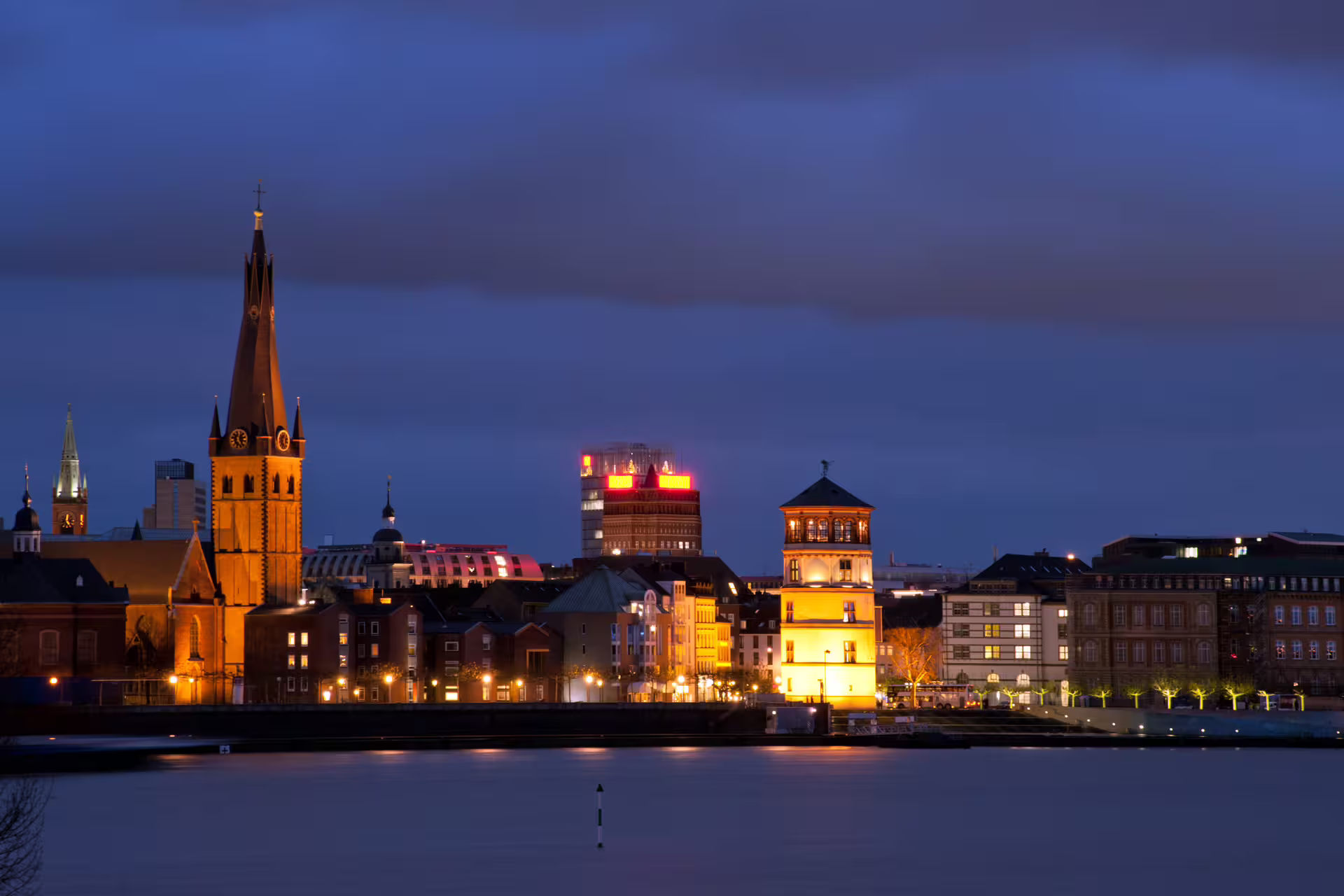 Düsseldorf skyline at dusk over the Rhine with St. Lambertus Church, seen on a 1-day audioguide walking tour