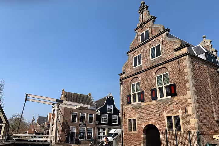 Historic Dutch village street with gabled brick houses, a drawbridge and canal near Amsterdam day tour