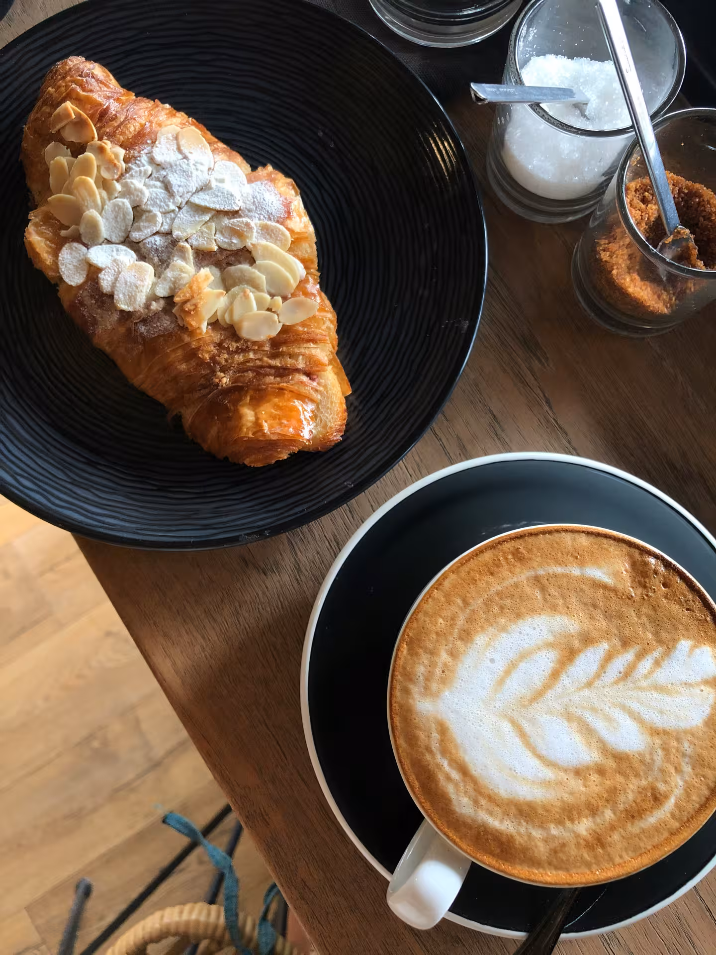 Delight in a fresh almond croissant paired with a beautifully crafted cappuccino, perfect for an early morning tour moment.
