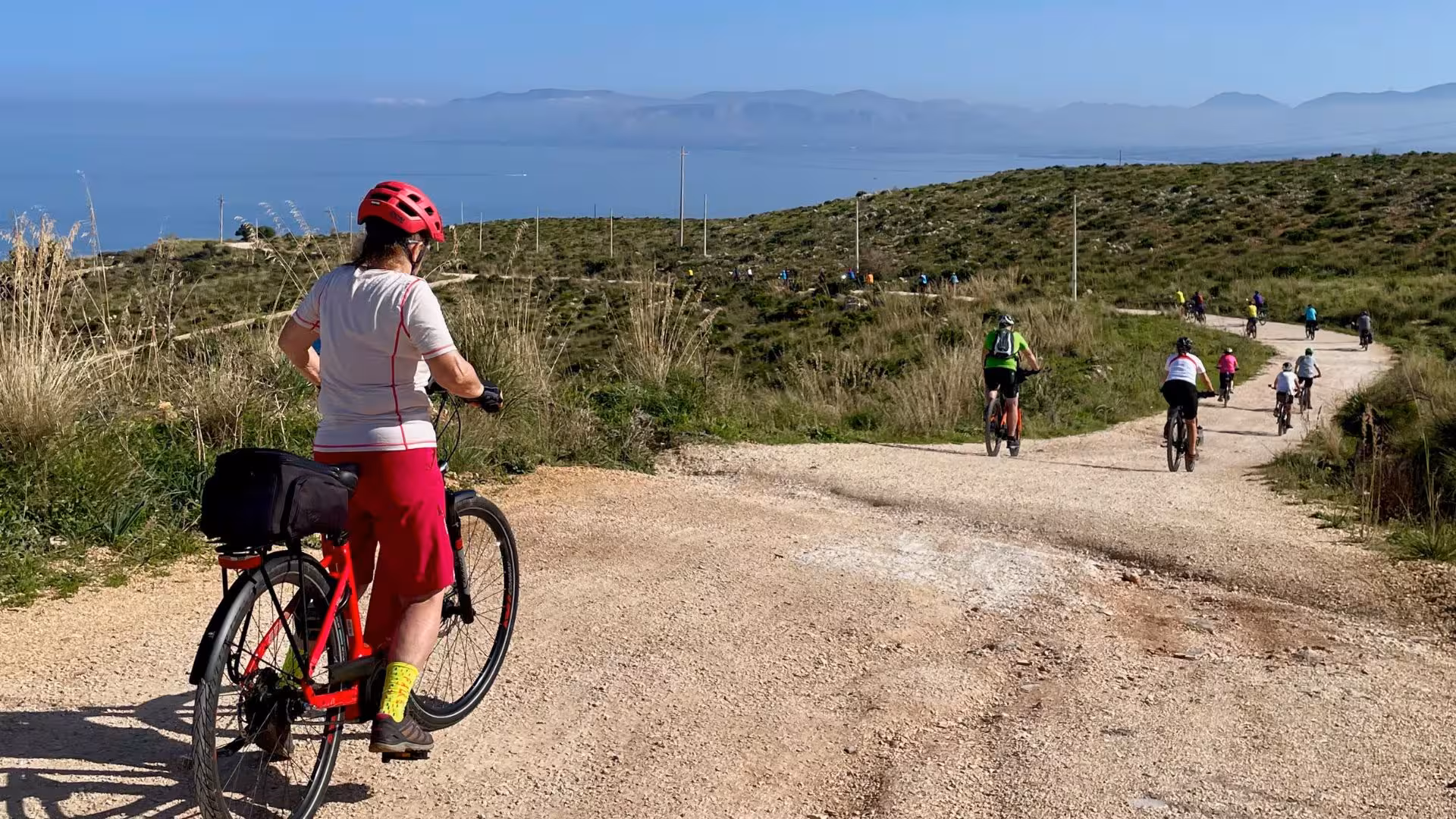 Cyclists enjoy a scenic ebike tour from Castellammare del Golfo to Cornino with views of lush hills and the sea.