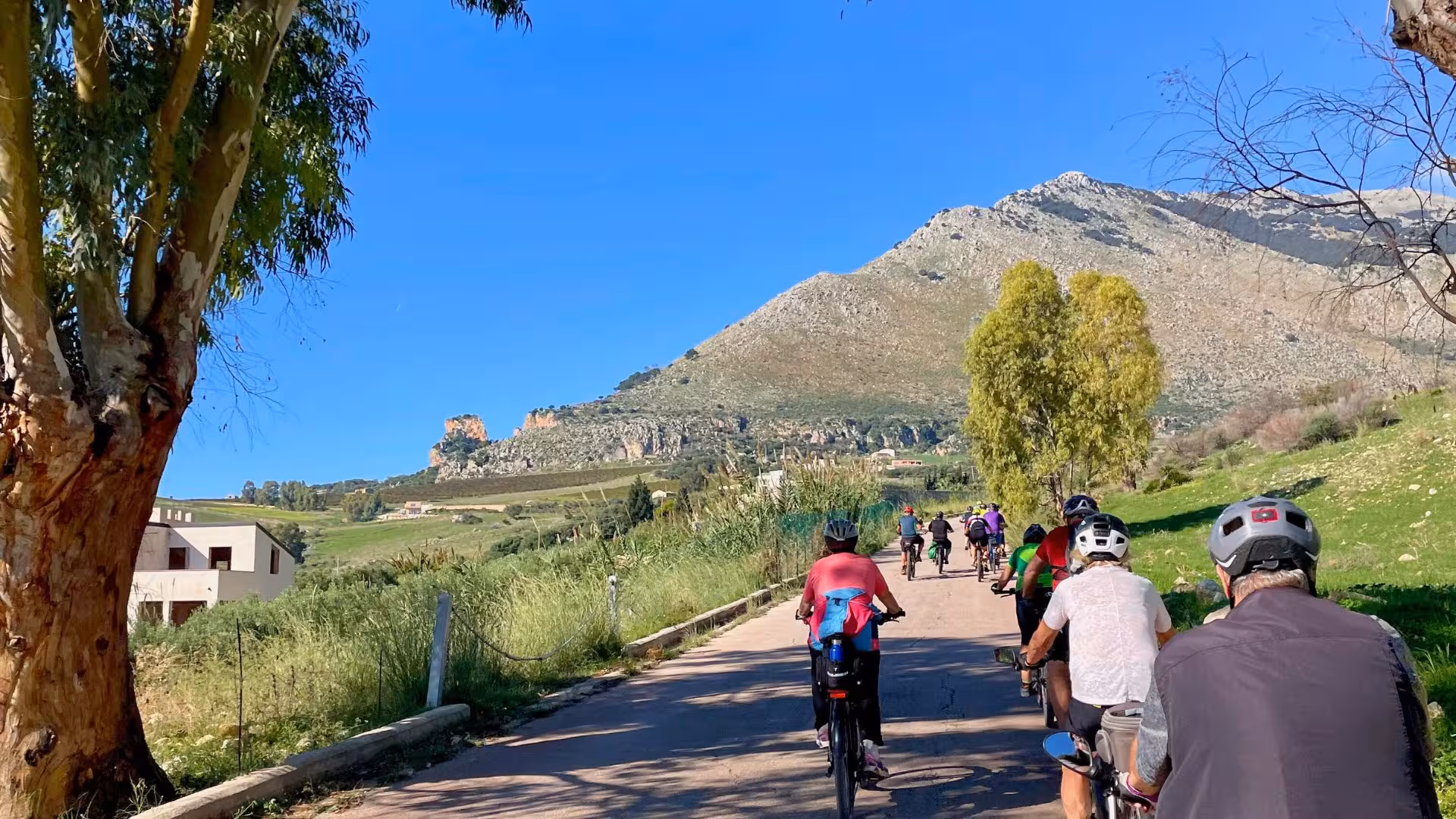 Cyclists enjoy scenic ebike tour with mountain views near Castellammare del Golfo on the way to Segesta temple.