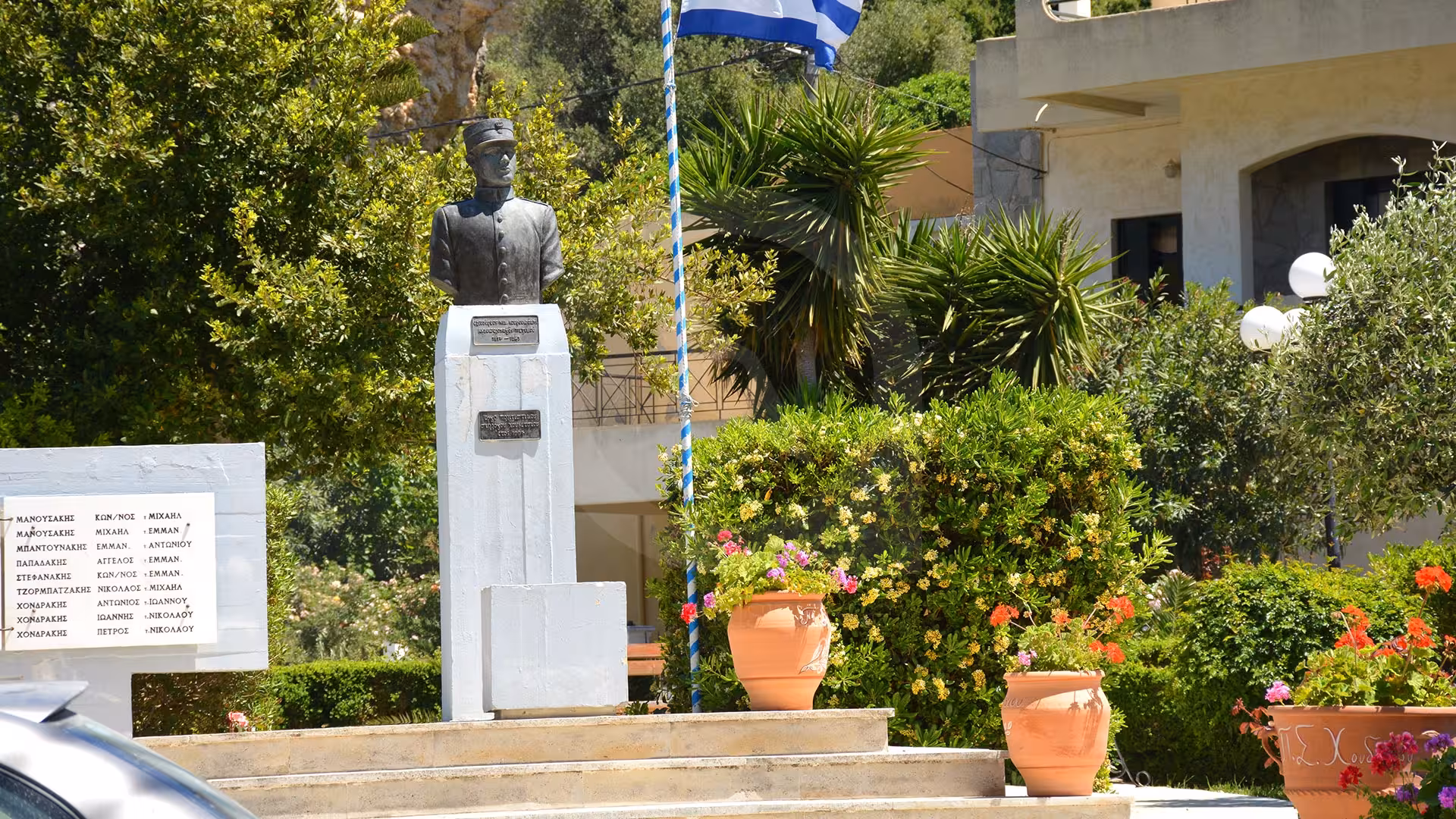 Village memorial statue and Greek flag on Crete, a cultural stop on the eco bike tour from Knossos