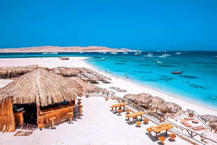 Eden Island beach from Hurghada boat trip, thatched huts on white sand and turquoise Red Sea lagoon