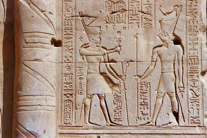 Ancient Egyptian relief carvings and hieroglyphs on temple wall at Edfu, featured on Luxor to Edfu and Kom Ombo tour