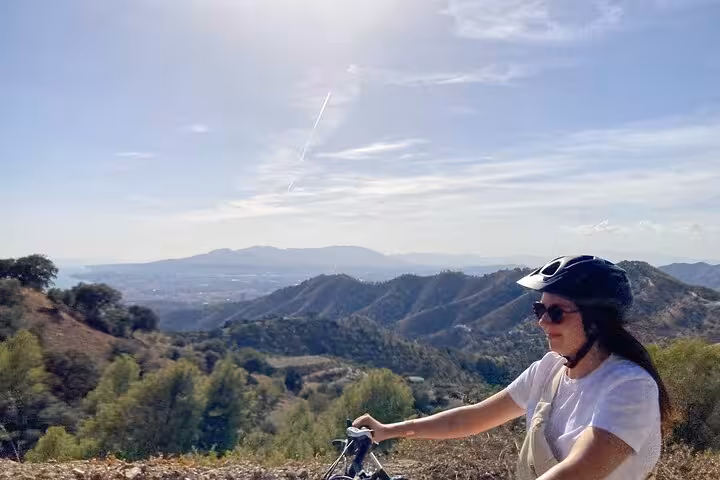 Rider on e-fat bike enjoying panoramic mountain views near Málaga on a 10-hour self-guided rental adventure
