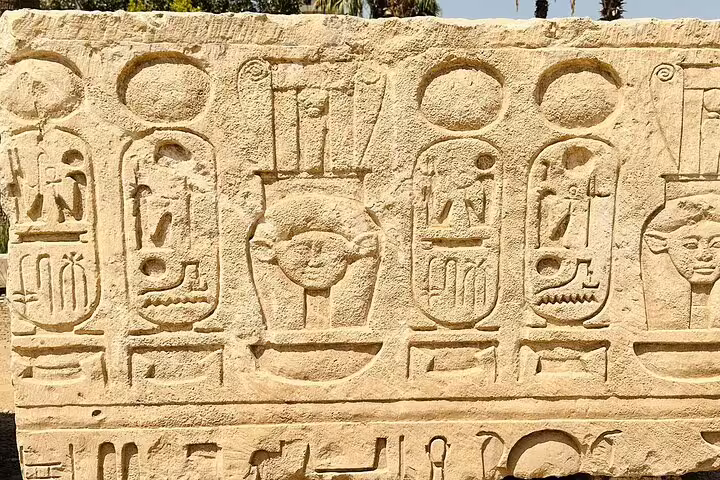 Ancient Egyptian hieroglyphs carved in sandstone temple wall, highlight of 6-day Egypt tours package