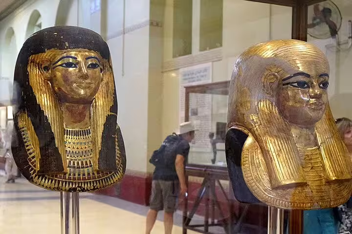 Gilded ancient Egyptian funerary masks at Cairo Museum, included in Hurghada to Giza pyramids day tour