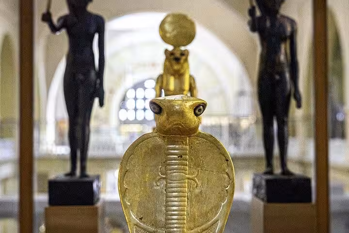 Ancient Egyptian gold cobra amulet in museum display, featured on VIP Giza Pyramids and Grand Egyptian Museum tour