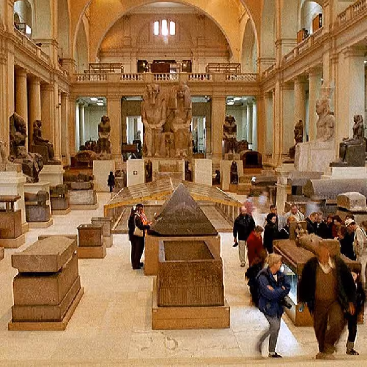 Inside Egyptian Museum Cairo gallery with ancient statues and sarcophagi, part of private Giza tour day trip