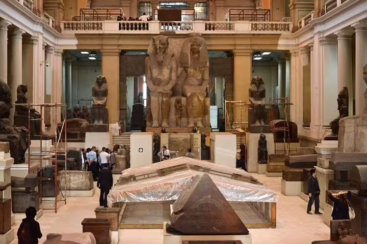 Close view of Egyptian Museum Cairo central hall with colossal statues and sarcophagus on private day trip