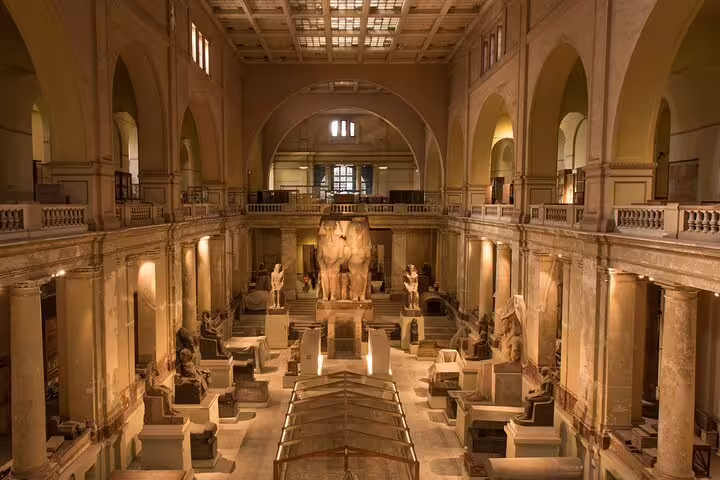 Evening-lit main gallery of the Egyptian Museum Cairo with ancient statues, private guided tour experience
