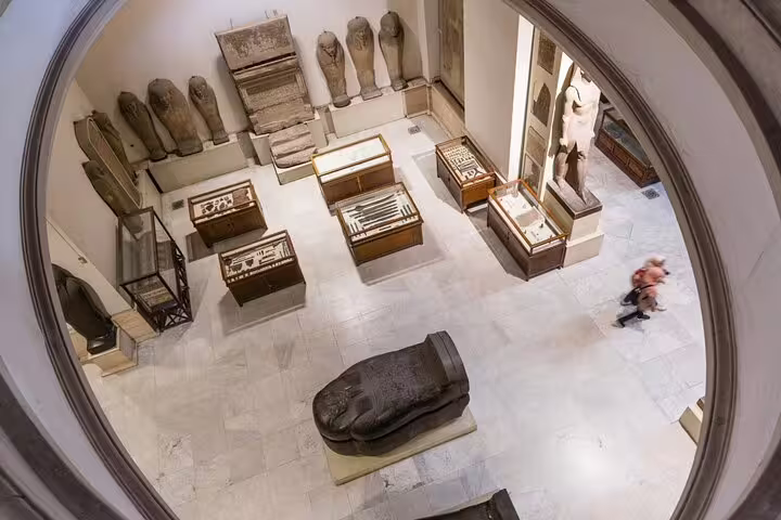 Egyptian Museum Cairo gallery with ancient sarcophagi and artifacts on a private Cairo tour package