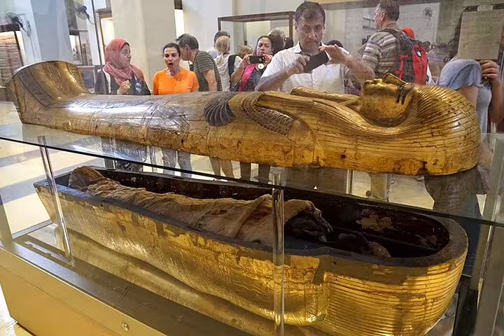Golden sarcophagus and mummy display at Egyptian Museum Cairo on semi-private Hurghada to Giza tour