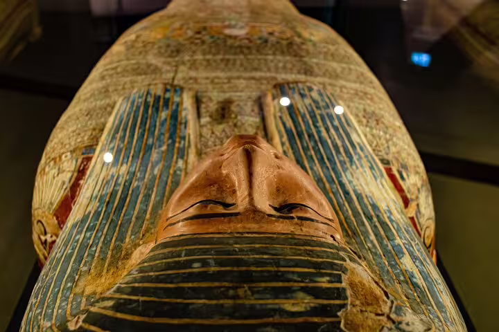 Painted ancient Egyptian sarcophagus mask displayed in Egyptian Museum Cairo on antiquities tour