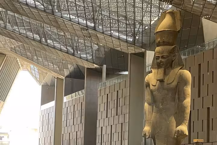 Colossal ancient Egyptian statue inside the Grand Egyptian Museum on private Cairo tour with Citadel and Khan El Khalili