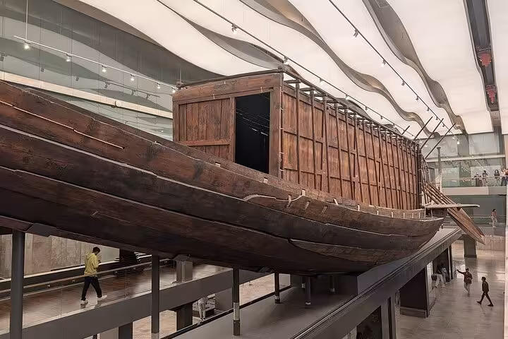 Ancient Egyptian wooden boat exhibit inside the Grand Egyptian Museum, part of Giza Pyramids and lunch tour