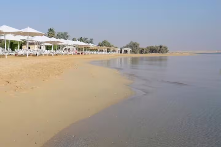 Sandy El Ain Sokhna Red Sea beach with umbrellas and loungers, private overnight trip from Cairo resort stay