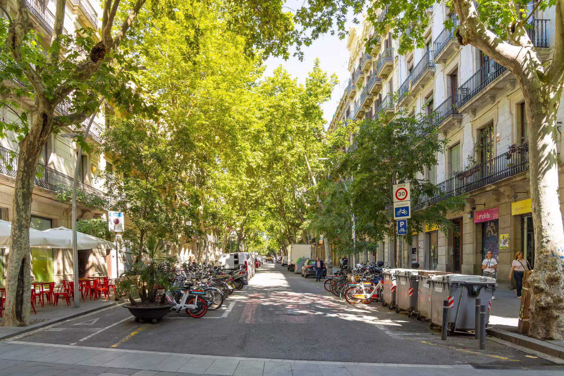 Tree-lined El Born street in Barcelona with bikes and cafes, scene from a 1-day self-guided audioguide walk