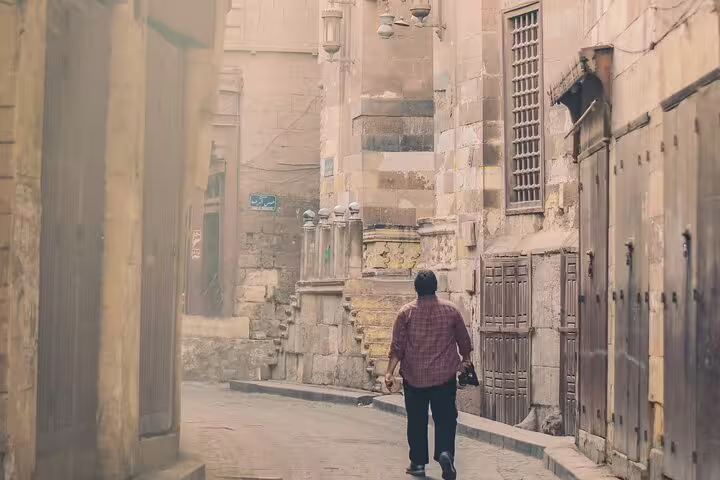 Traveler walking in El-Moez Street, Islamic Cairo alleyway on the Giza Pyramids, Memphis, Saqqara and Dahshur tour