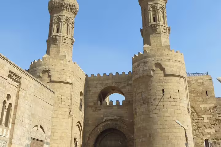 Medieval stone towers and arched entrance in Islamic Cairo near El-Muizz Street, part of Cairo Tower dinner tour