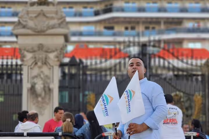 Tour guide holding flags meeting guests for a private El Sokhna Port to Cairo tour to Pyramids, Citadel and bazaar