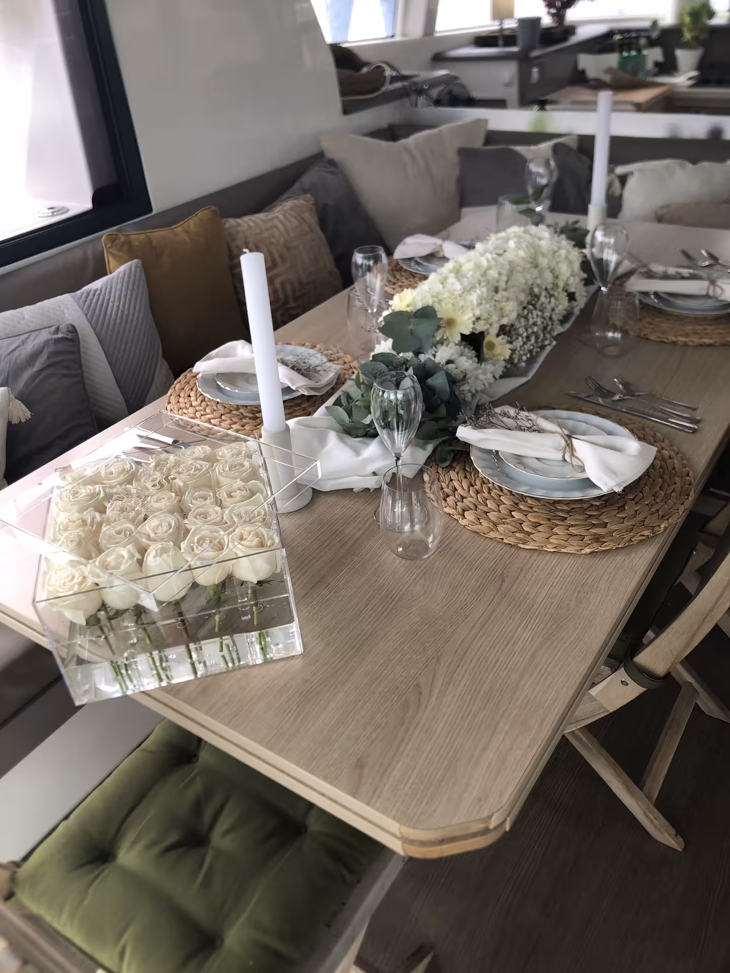 Elegant private yacht dinner setup with white roses, candles, and place settings for a marriage proposal