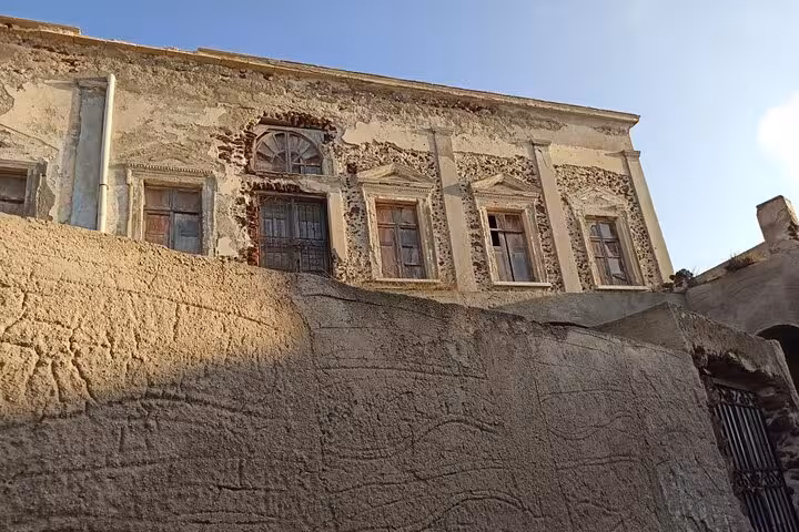 Historic mansion ruins in Emporio, Santorini, showing old stonework and windows on highlights tour