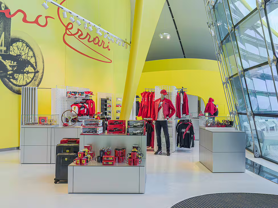 Ferrari gift shop inside Enzo Ferrari Museum Modena, with official merchandise and souvenirs near entrance