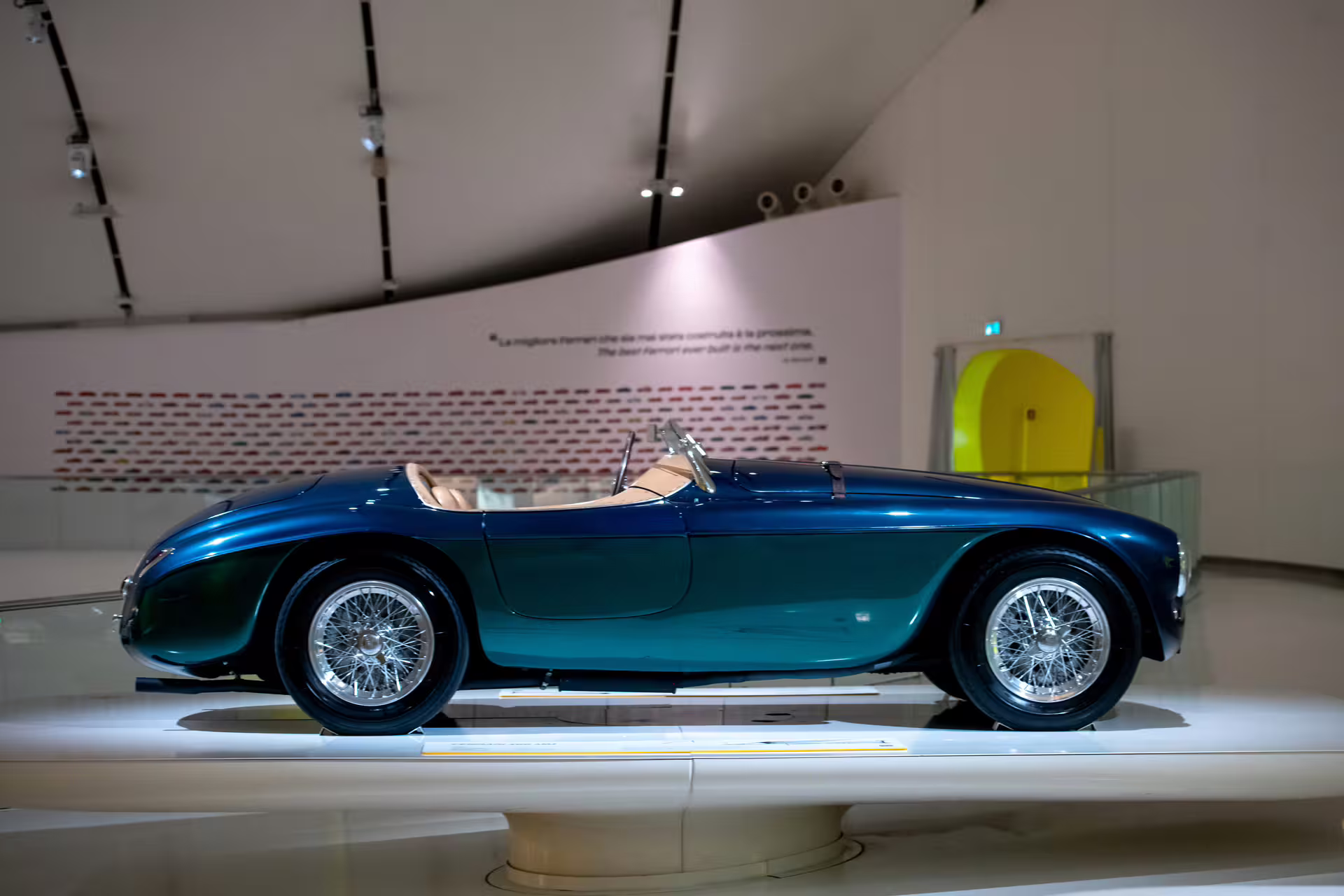 Classic blue Ferrari convertible exhibit at Enzo Ferrari Museum Modena, vintage car display with entrance ticket