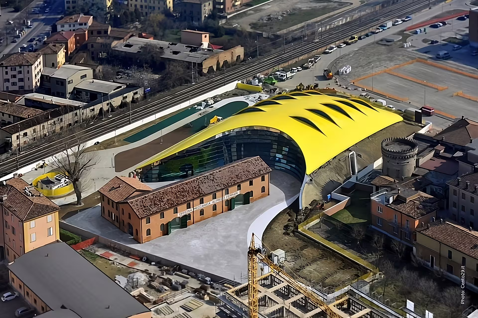 Bird’s-eye view of Enzo Ferrari Museum in Modena, iconic yellow roof and entrance area for ticket holders