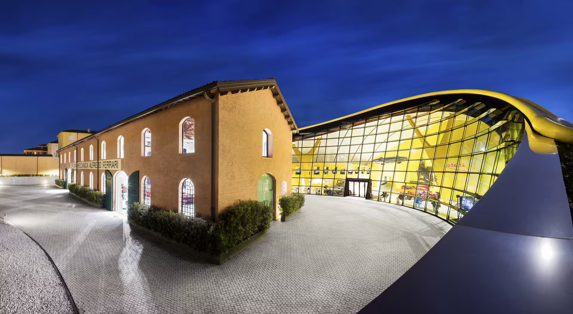 Discover the stunning architecture of Enzo Ferrari Museum in Modena, a blend of historic and modern design under a night sky.