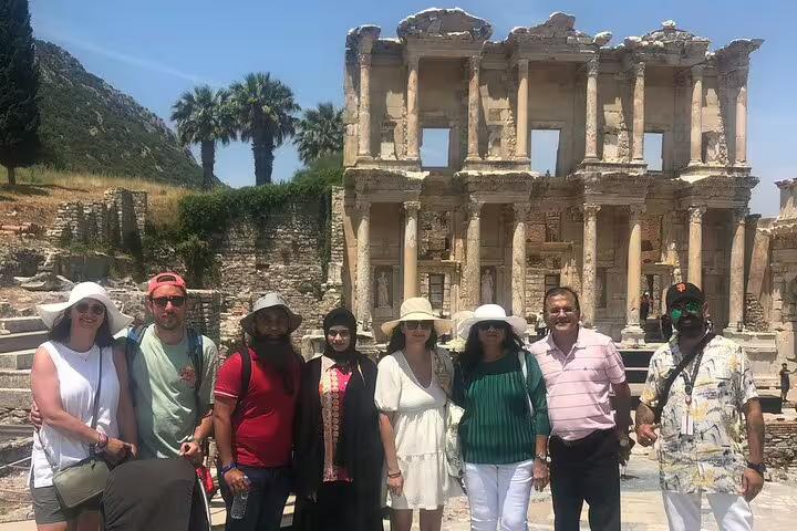 Visitors posing in front of the Celsus Library in Ephesus during a private tour with entry fees and lunch included.