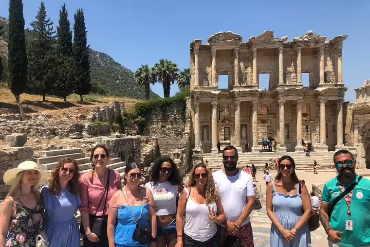 Group of tourists enjoying a sunny day at the historic Library of Celsus in Ephesus on a guided tour from Kusadasi.