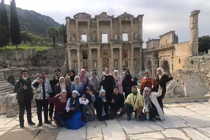 Group of tourists posing in front of the ancient Library of Celsus during a private tour of Ephesus from Kusadasi.
