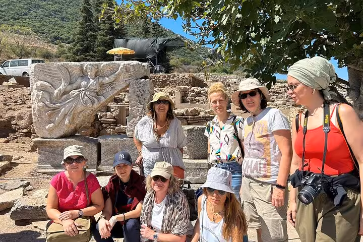 Small group at Ephesus archaeological site among ancient carved stones on private cruiser shore excursion, tickets
