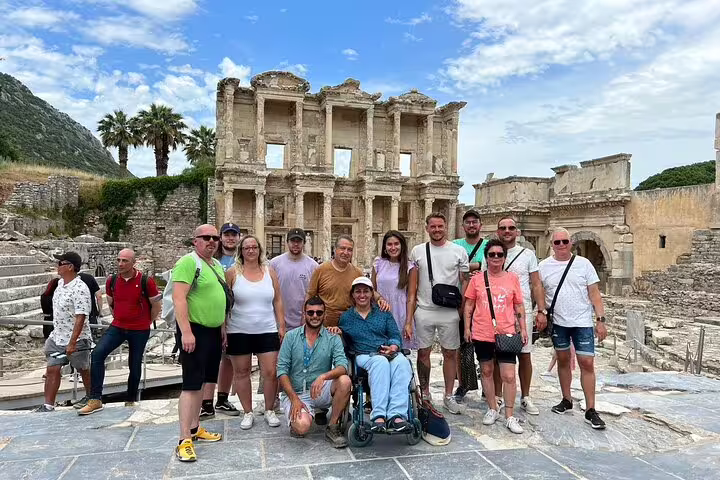 Group of travelers enjoying a sunny day at the ancient Ephesus ruins, featuring the iconic Celsus Library.
