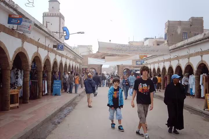 Crowded Essaouira medina market street with arched souks, seen on a Marrakech to Essaouira private day tour