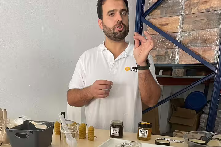 Guide explaining beekeeping products with honey jars and beeswax candles on display in Evora.