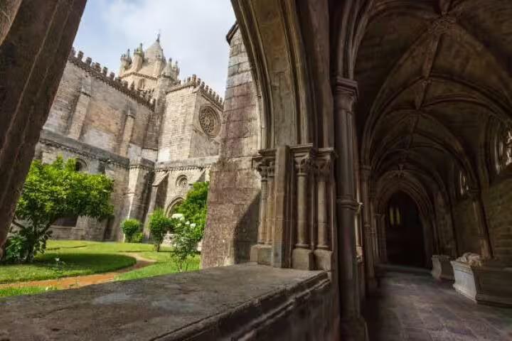 Explore the historic cloisters of Évora Cathedral, showcasing Gothic architecture and lush gardens on the Lisbon to Évora tour.