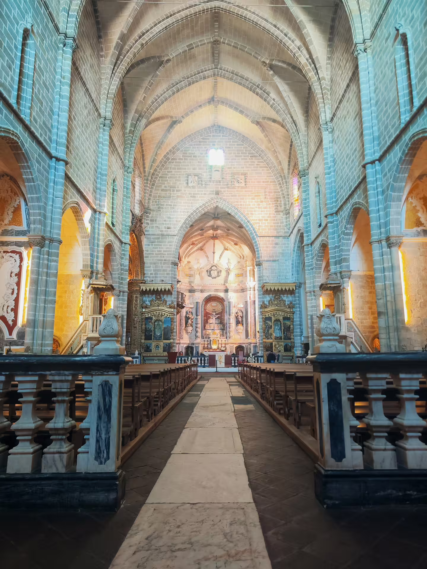 Interior of Évora cathedral showcasing Gothic arches and ornate altar, a highlight of the UNESCO tour from Lisbon.