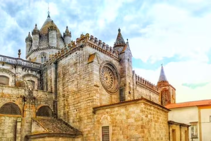 Marvel at the intricate stone facade and Gothic spires of Évora Cathedral, a highlight of the Lisbon to Évora UNESCO tour.