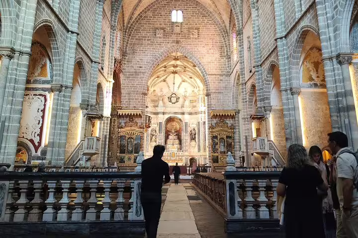 Visitors explore the ornate interior of Évora Cathedral, showcasing its intricate architecture and historical significance.