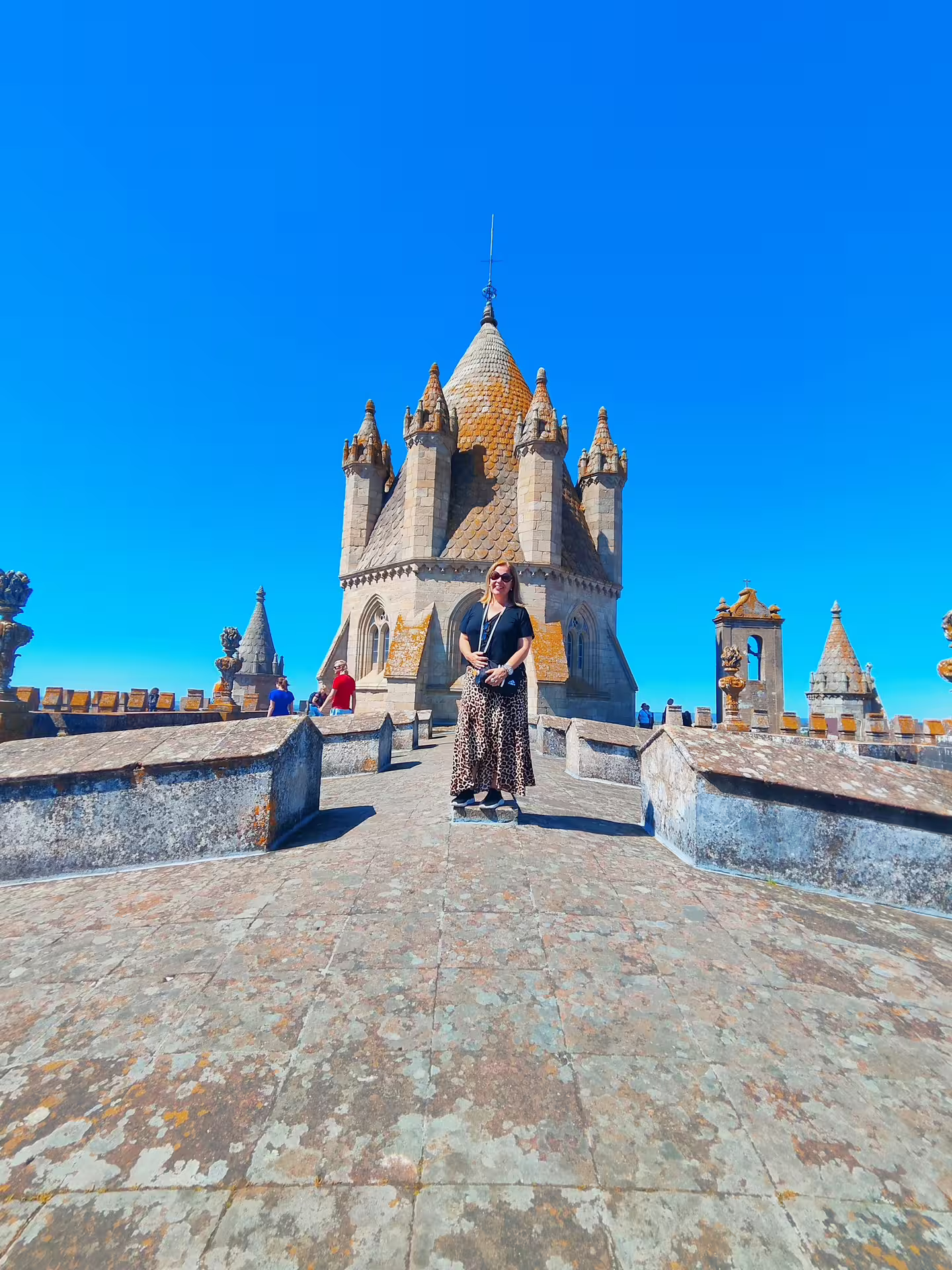 Visitor at the rooftop terrace of Évora Cathedral, showcasing its medieval architecture under a clear blue sky.