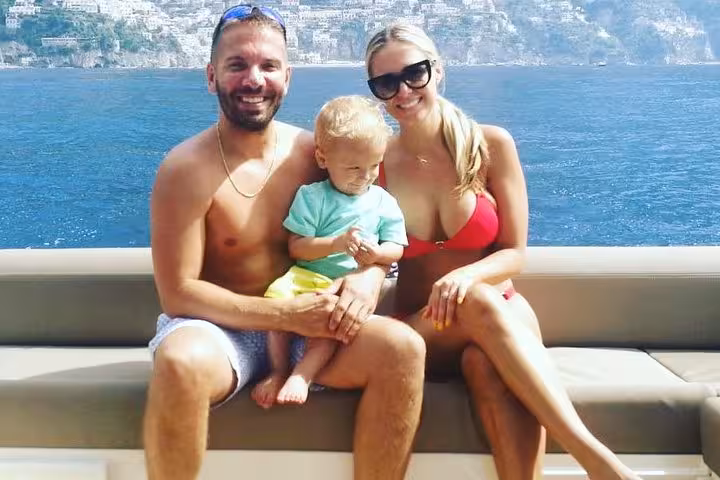 Family enjoying a sunny day on an excursion boat with stunning views of Capri's coastline.