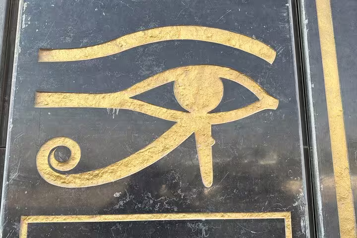 Golden Eye of Horus emblem on stone, a highlight on private Pyramids and Grand Egyptian Museum day tour