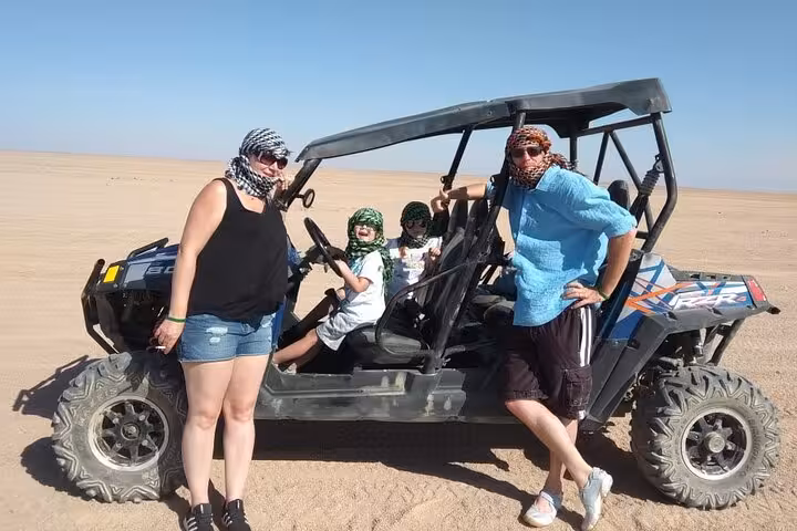 Family posing by off-road buggy in Sinai desert from Sharm El Sheikh, guided ride with pickup included