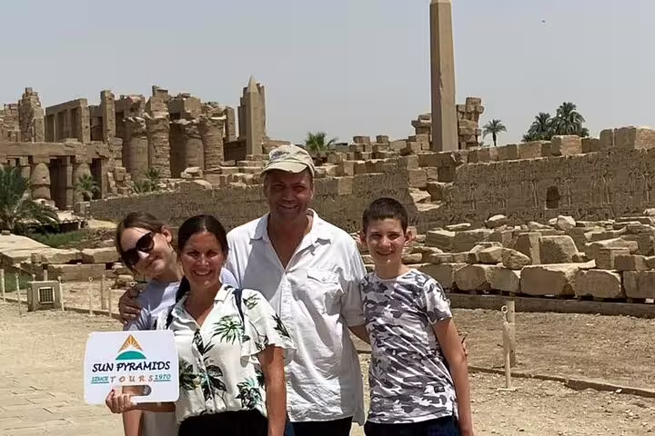 Family at Karnak Temple ruins in Luxor on private sleeper train trip from Cairo, guided day tour photo stop