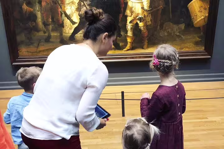 Family guided Rijksmuseum tour viewing Rembrandt’s Night Watch, uncovering stories behind Dutch masters