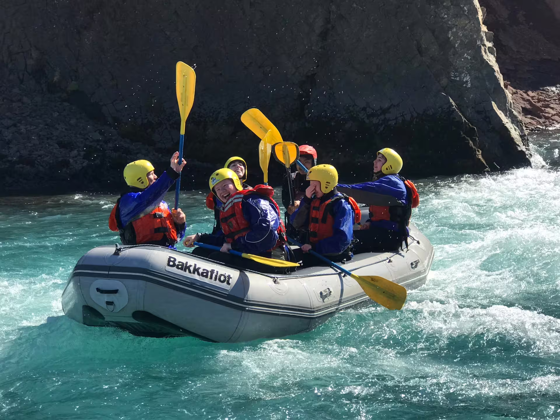 Family enjoying an exhilarating river rafting adventure, paddling through turquoise rapids in a scenic outdoor setting.